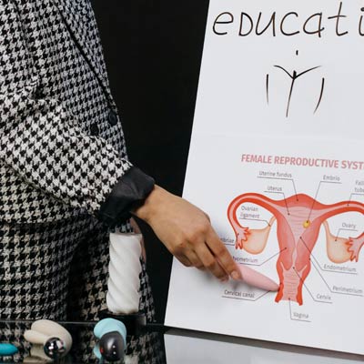 Sex education category - woman uses vibrator to point at uterus diagram